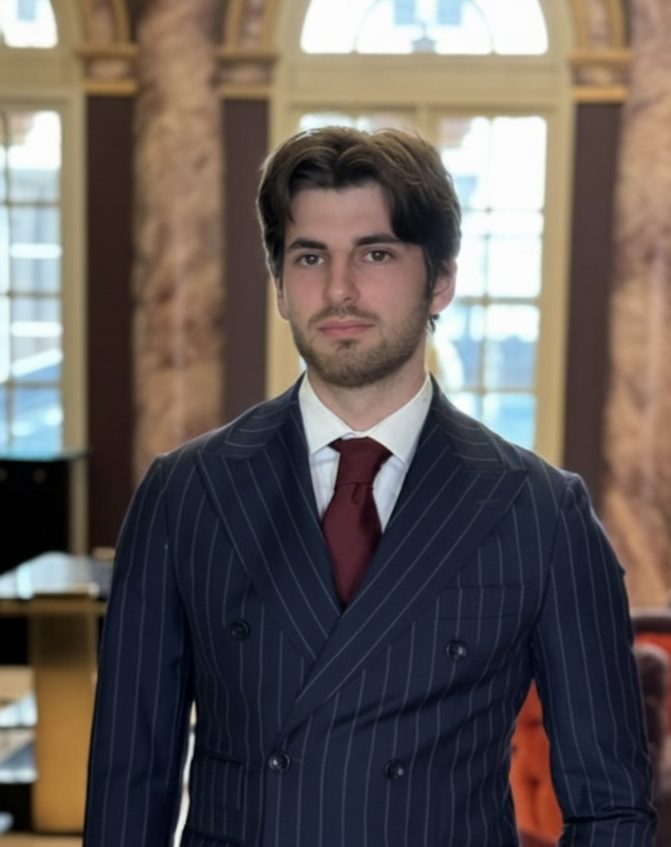 Alexis Dubain en costume, dans le hall d'un hôtel